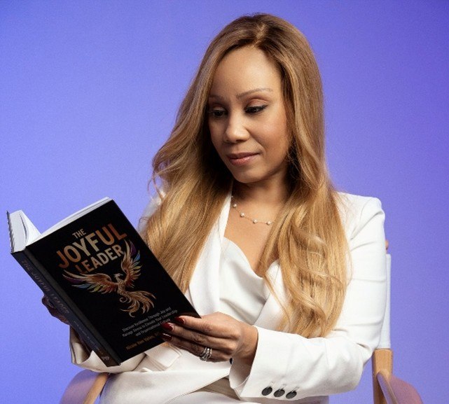Nicole Van Valen reading The Joyful Leader book, representing leadership clarity and sustainable performance