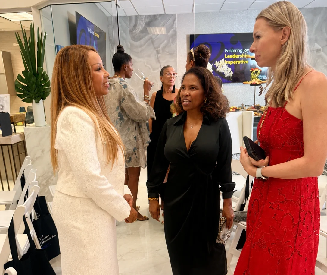 Nicole Van Valen smiling in conversation at a professional event, warm natural light